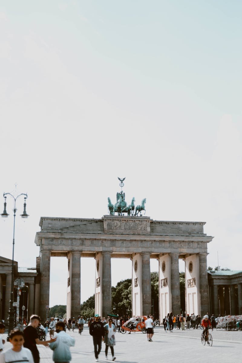 Scenic view of Brandenburg Gate in Berlin, bustling with tourists.