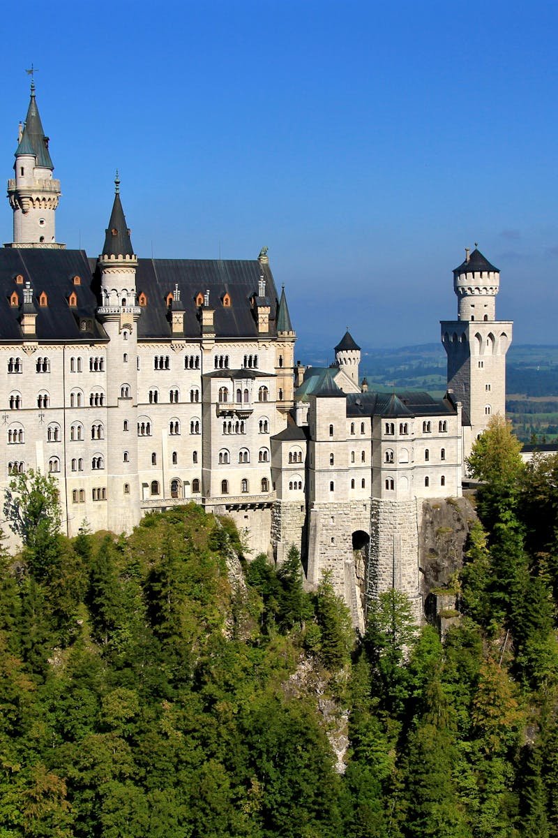 Aerial view of the iconic Neuschwanstein Castle surrounded by lush greenery in Bavaria, Germany.