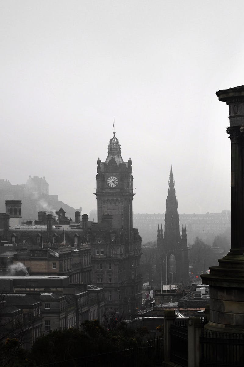 A scenic view of Edinburgh's iconic Calton Hill under grey skies, featuring historic monuments.