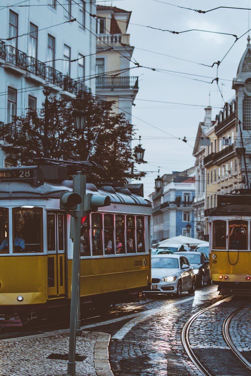 Scenic view of trams navigating the charming streets of Lisbon at dusk, capturing urban life and transportation.