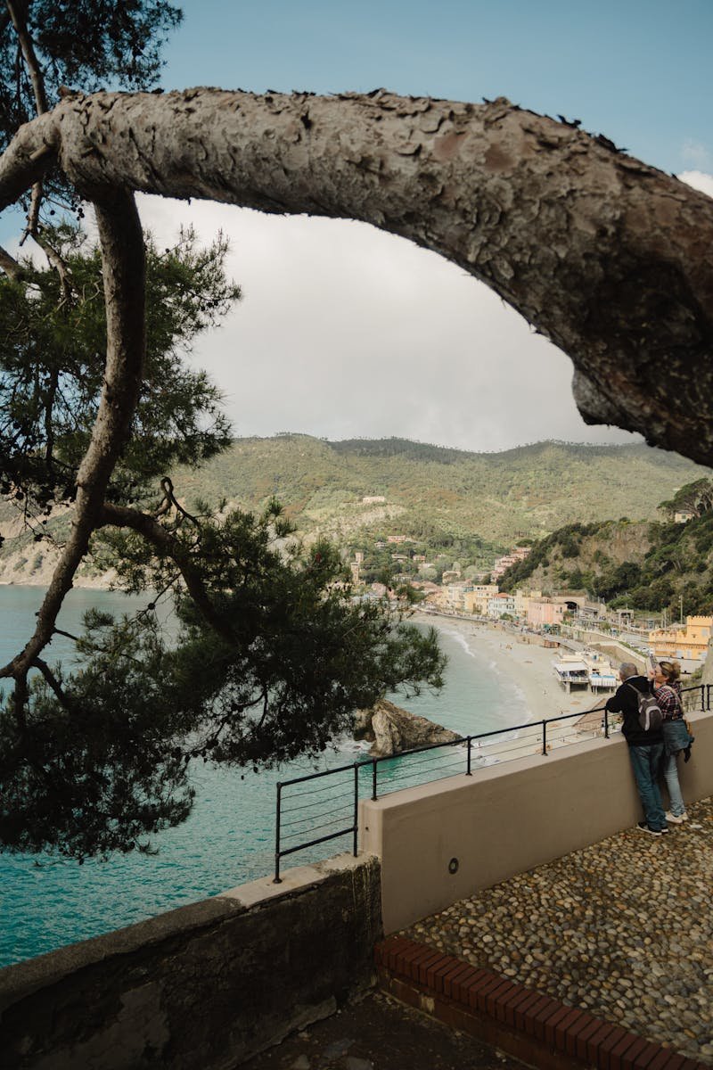 Couple enjoying a peaceful view of Italian coastline and mountains from a scenic overlook.