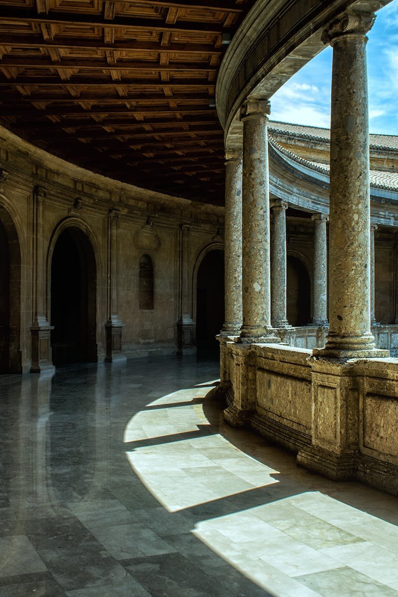 Stunning architectural view of Alhambra's courtyard in Spain, showcasing historical design and stone columns.