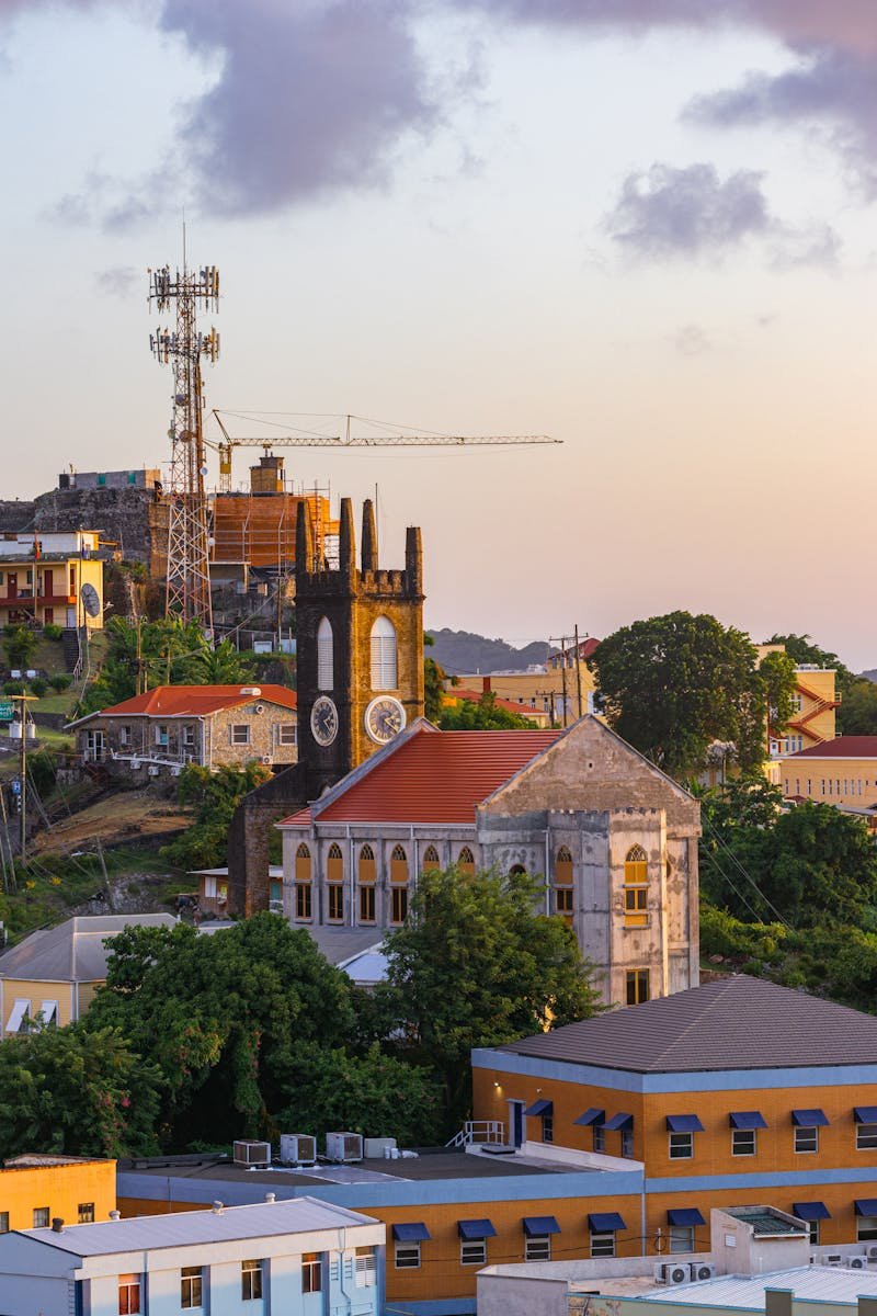 Aerial shot of a historic cathedral amidst an urban setting at sunset, featuring colorful architecture.