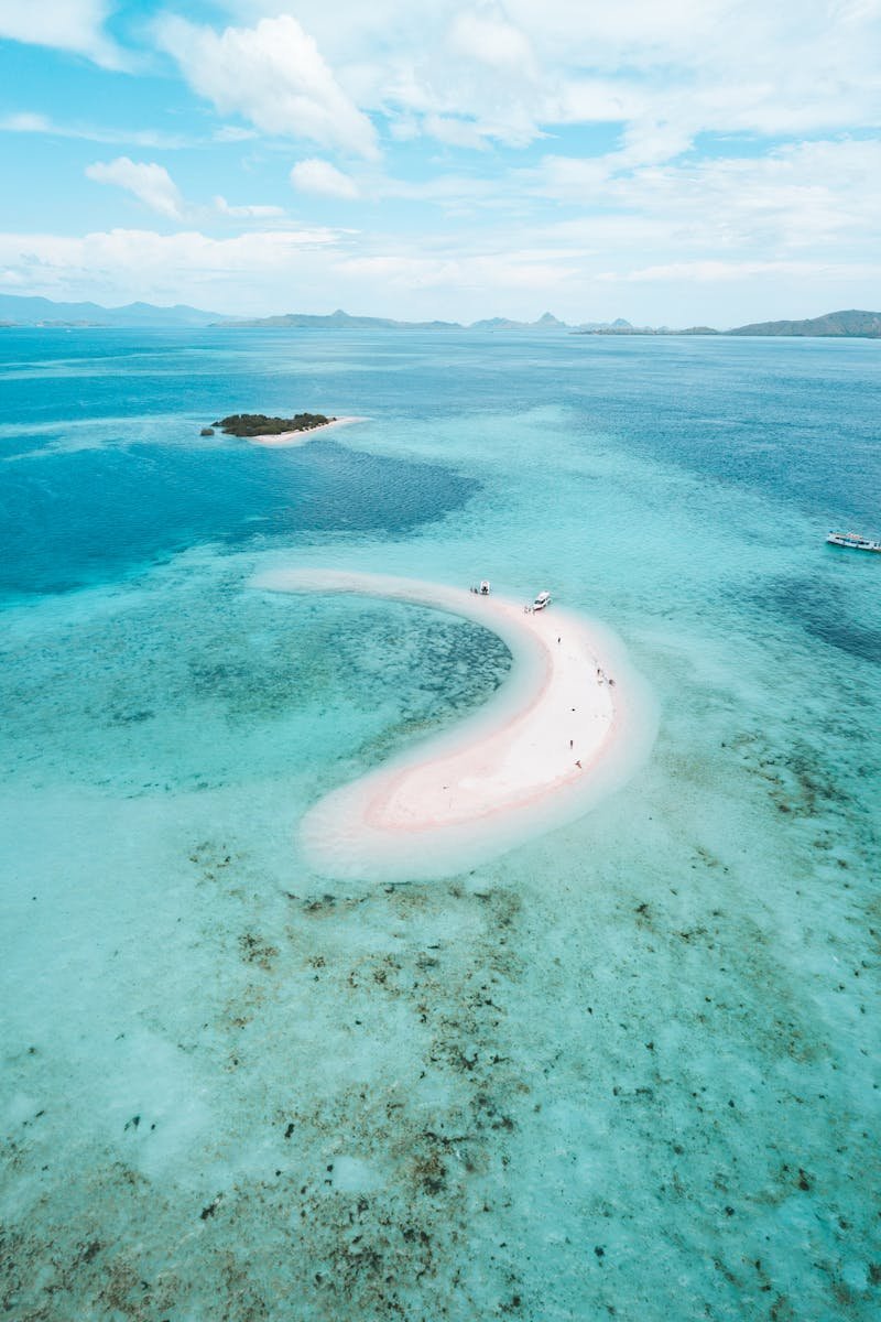 A stunning aerial view of a pink beach surrounded by turquoise waters in East Nusa Tenggara, Indonesia.