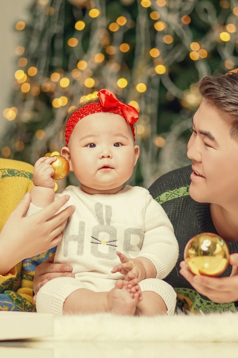 Smiling family celebrates Christmas with gifts and ornaments indoors in Ulaanbaatar.