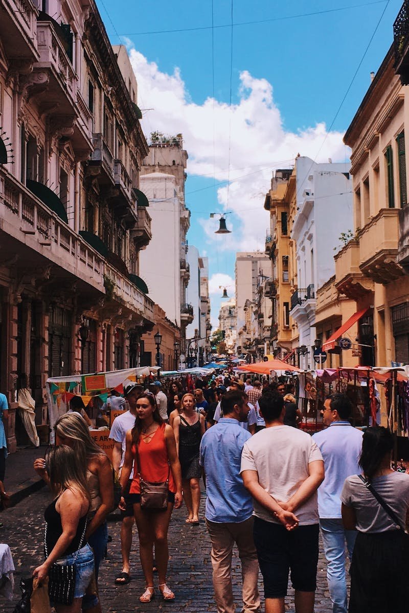 Bustling San Nicolas street market in Buenos Aires with stalls and crowds under a clear sky.