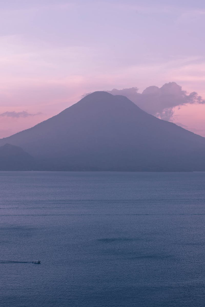 A breathtaking view of a sunset over Lake Atitlán in Guatemala with a volcano silhouette.