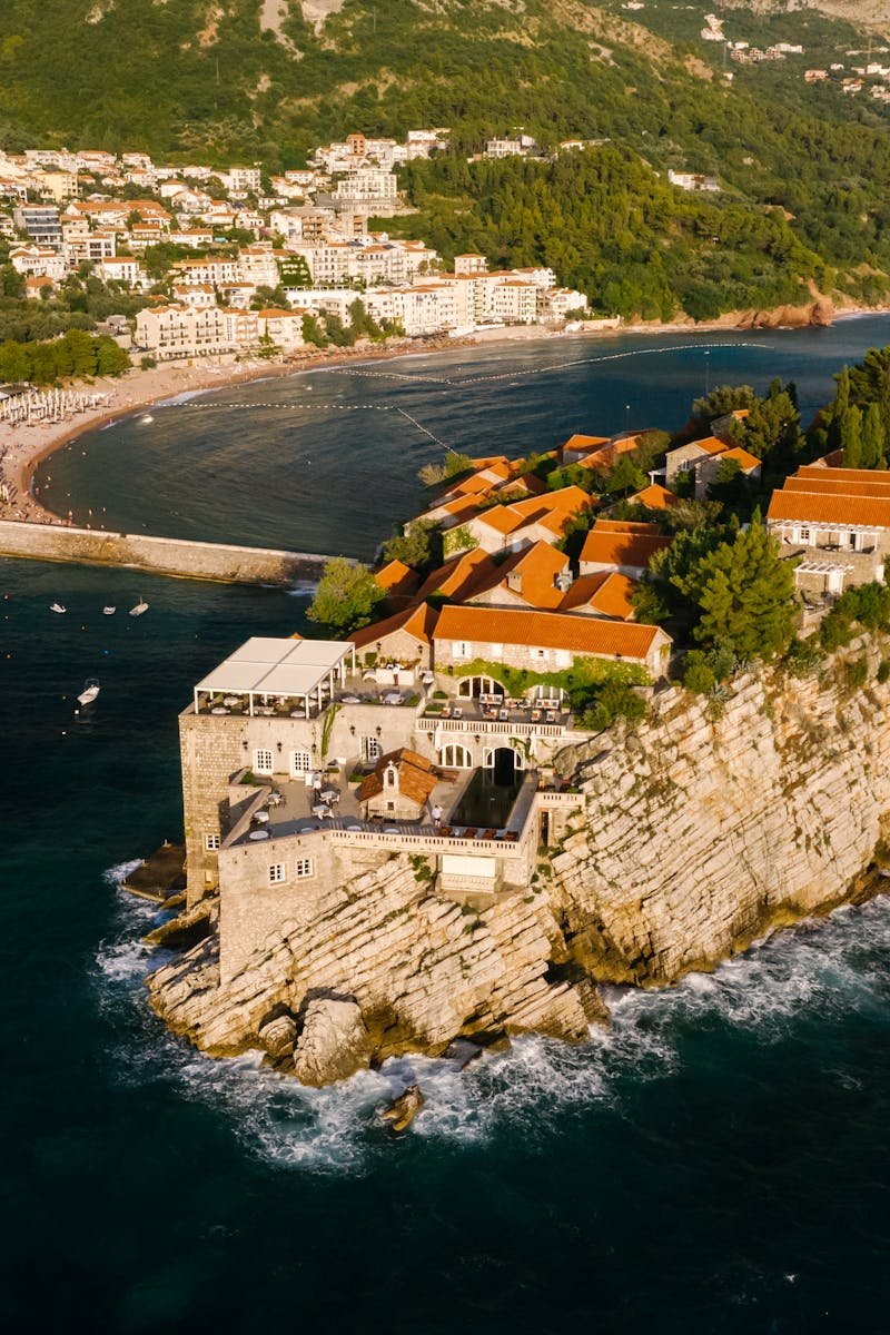 Stunning aerial shot of Aman Sveti Stefan luxury resort on a rocky islet in Montenegro.