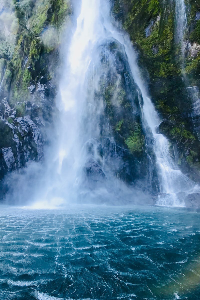A stunning waterfall cascading into a turquoise pool in Southland, New Zealand.