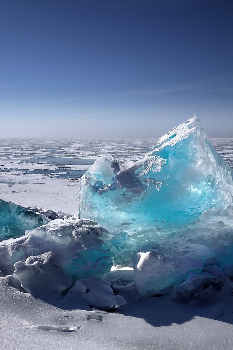 Captivating ice formation on a frozen lake under a bright blue sky during winter.