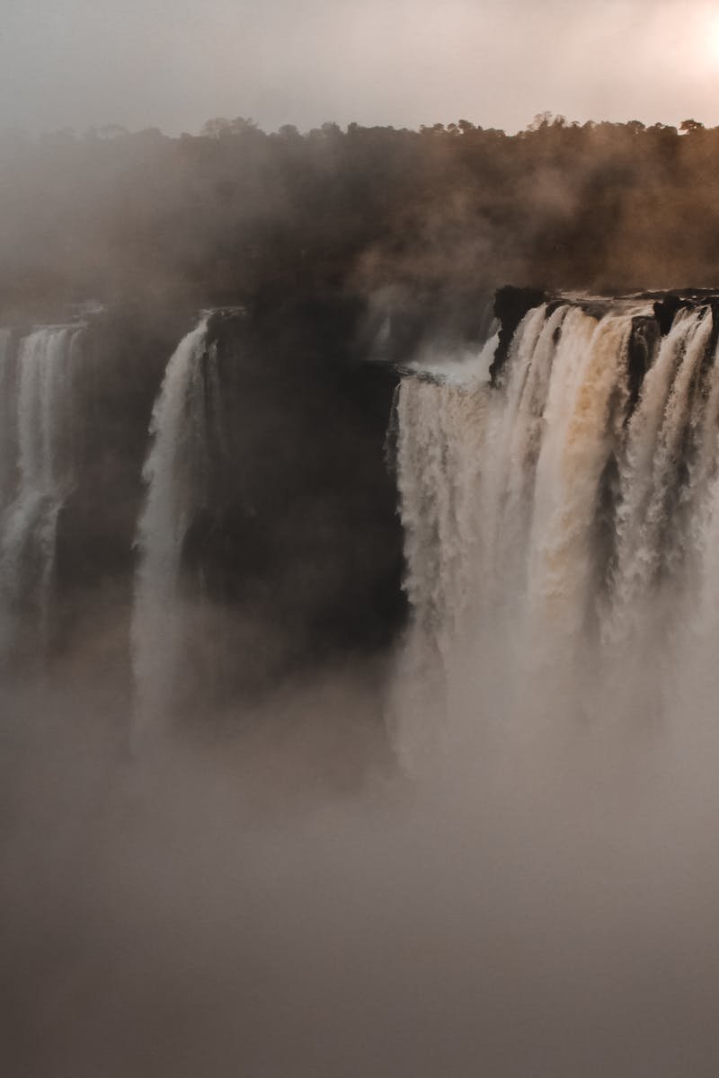 A stunning view of a grand waterfall enveloped by mist, showcasing nature's beauty.