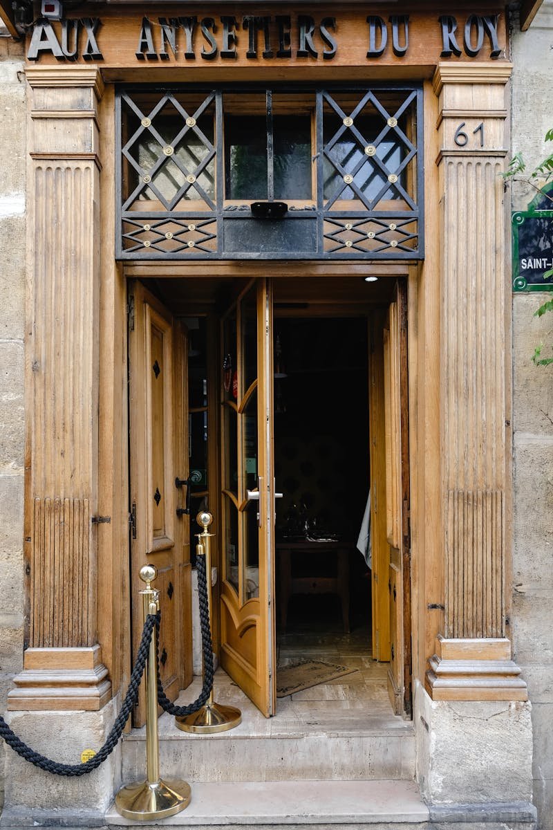 Elegant wooden entrance of Aux Antifetiers du Roy in Paris, showcasing classic architectural design.